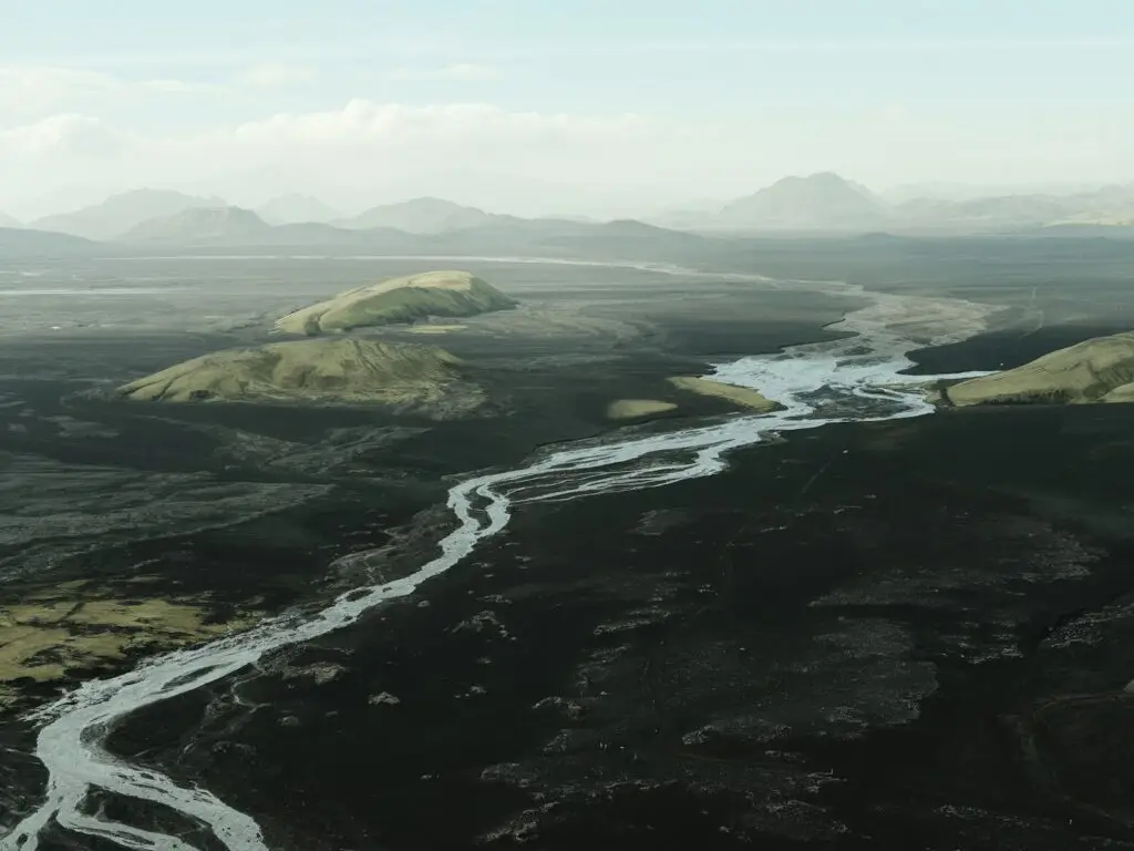 A winding river flows through a vast, dark landscape.
